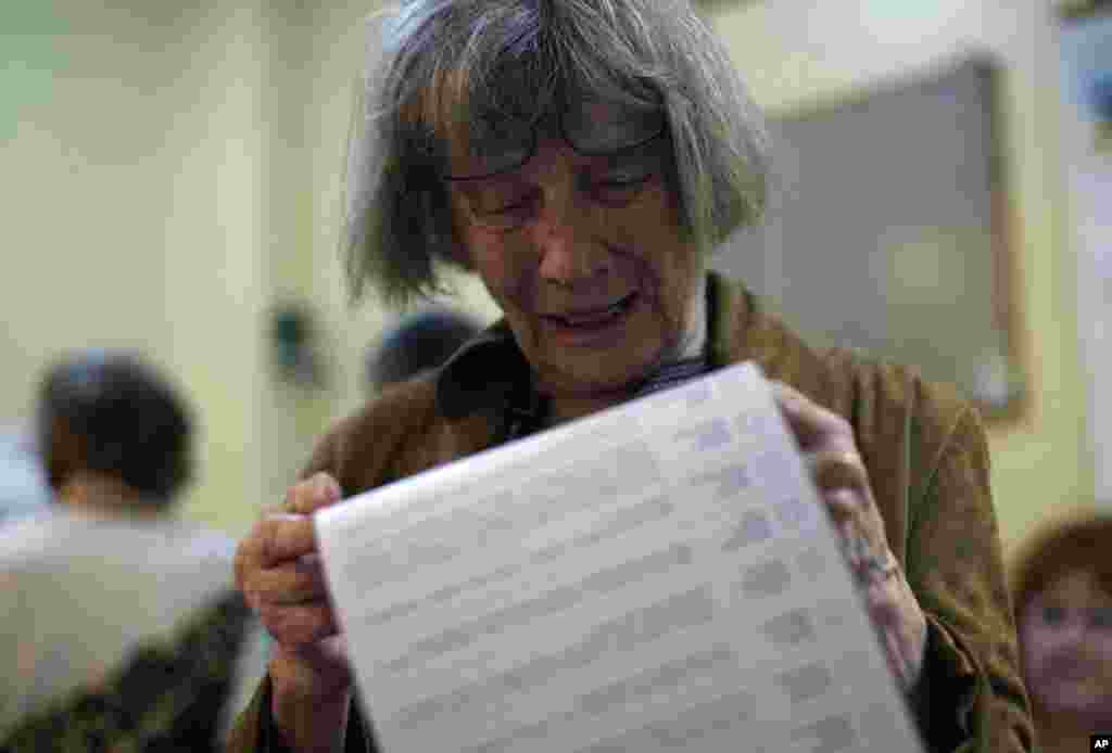 A woman reads her ballot at a polling station in Mariupol.