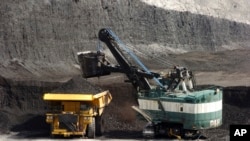FILE - A mechanized shovel loads a haul truck with coal at the Spring Creek coal mine near Decker, Mont., April 4, 2013. A federal judge in Montana says the Trump administration failed to consider the environmental effects of resuming coal sales from fede