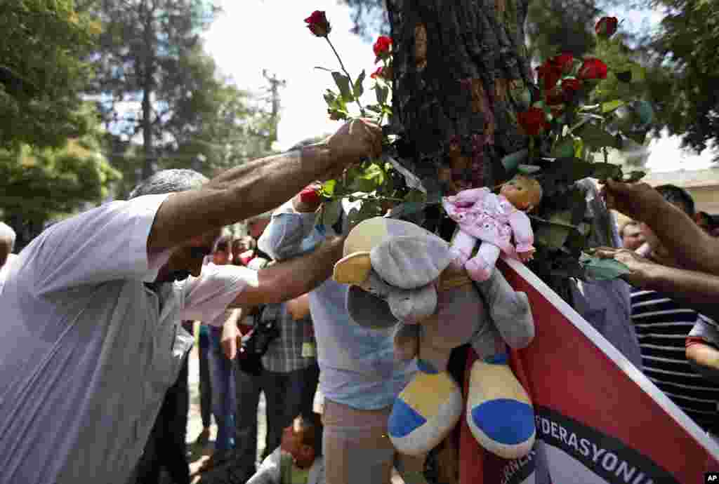 A man lays flowers at the makeshift memorial shrine at the site of a Monday explosion in the Turkish town of Suruc near the Syrian border, July 21, 2015.