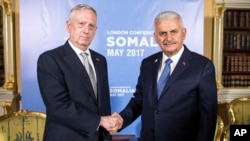 Turkey's Prime Minister Binali Yildirim, right, shakes hands with U.S. Secretary of Defense James Mattis, ahead of the Somalia Conference, in London, May 11, 2017. 