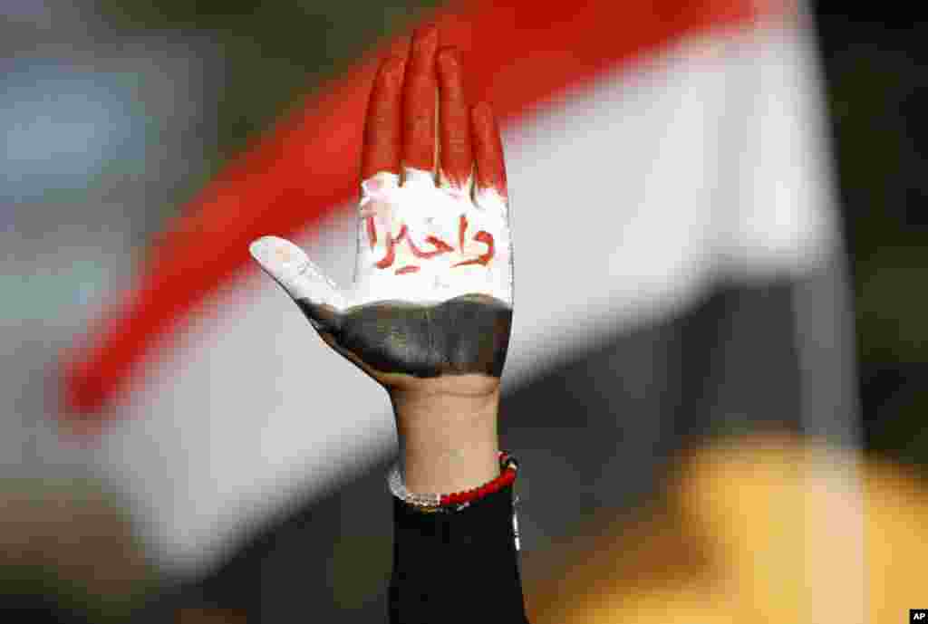 A woman displays her hand painted with Yemen's flag and Arabic writing that reads, "finally!" during a rally to show support for president Abed Rabbu Mansour Hadi, in Sanaa, Yemen, Thursday, Dec. 20.