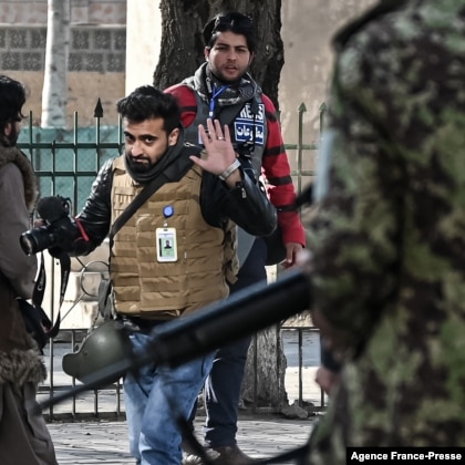 جنگجوی طالبان در جریان تظاهراتی در کابل به تاریخ ۲۸ دسمبر ۲۰۲۱ به سوی جمعی از خبرنگاران حرکت می‌کند. 
