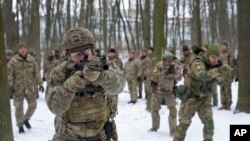 FILE - Members of Ukraine's Territorial Defense Forces, volunteer military units of the armed forces, train in a city park in Kyiv, Jan. 22, 2022.