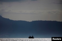 FILE - A fishing trawler anchors off the coast of Freetown, Sierra Leone, Nov.18, 2012.