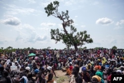 FILE - Thousands of people wait in the hot sun near the air drop zone in Leer, South Sudan, July 5, 2014.