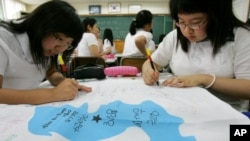 한국의 한 고등학교에서 남북통일에 관한 수업이 진행된 가운데, 학생들이 한반도기에 통일을 염원하는 문구를 적고 있다. (자료사진)