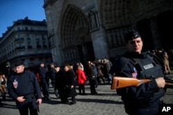 Police officers patrols in front of Notre Dame cathedral following Friday's attacks on Paris, Nov. 15, 2015. Thousands of French troops deployed around Paris on Sunday and tourist sites stood shuttered.