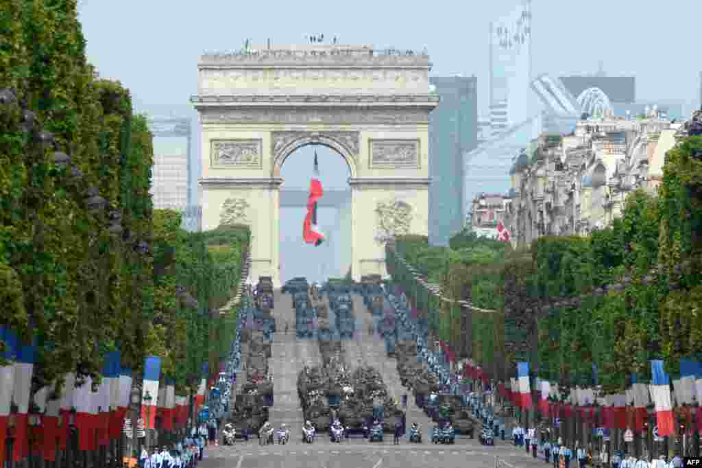 Armored vehicles drive down the Champs-Elysees avenue during the annual Bastille Day military parade in Paris, France.