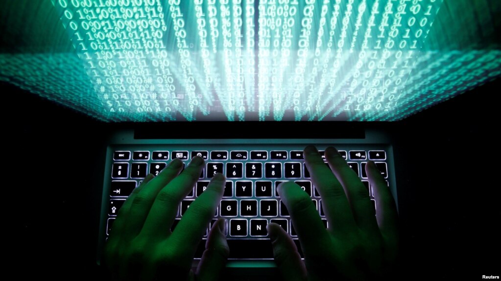 ຜູ້ຊາຍຄົນນຶ່ງກຳລັງຕີພິມໃສ່ຄອມພິວເຕີ ຢູ່ໃນພາບທີ່ສະແດງ ໃຫ້ເປັນຢູ່ນີ້.