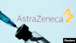 A vial and sryinge are seen in front of a displayed AstraZeneca logo in this illustration taken January 11, 2021. REUTERS/Dado Ruvic/Illustration/File Photo