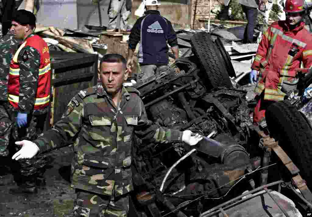 Policemen walk in front of burned barricade during a protest against Burundian President Pierre Nkurunziza's decision to run for a third term in Bujumbura, Burundi, May 13, 2015.