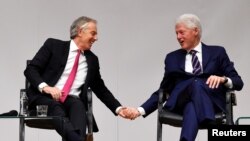 Tony Blair and Bill Clinton hold hands during an event to celebrate the 20th anniversary of the Good Friday Agreement, in Belfast, Northern Ireland, April 10, 2018.