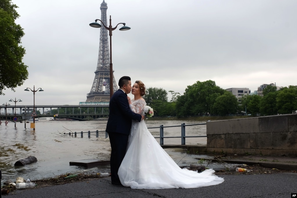 一对中国夫妇在法国巴黎的涨水的塞纳河畔，在艾菲尔塔前，拍摄结婚照 （2016年6月3日）