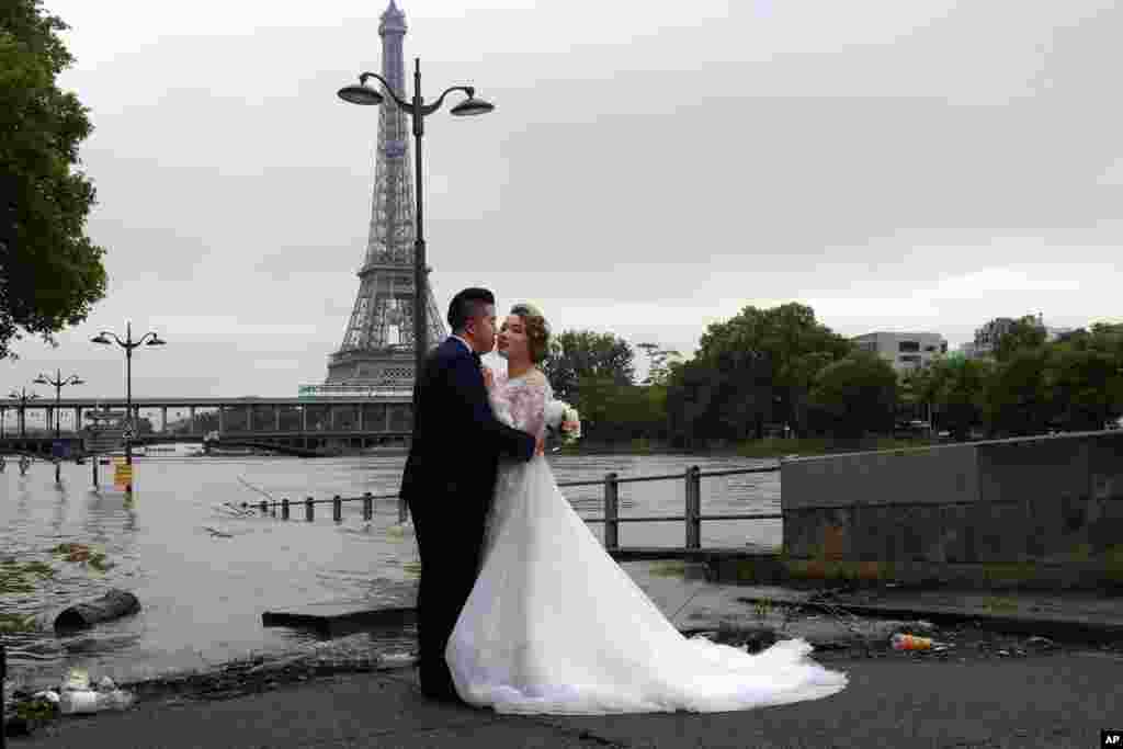 Paris Eyfel Kulesi önünde Sen nehri kıyısında Çinli gelin ve damat.