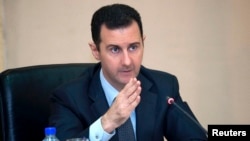 FILE - Syria's President Bashar al-Assad heads a cabinet meeting in Damascus, in this handout photograph distributed by Syria's national news agency SANA, Feb. 12, 2013.