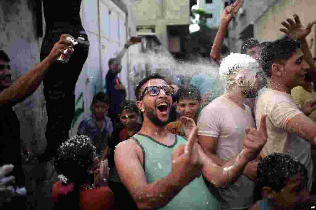 Palestinian youth and children spray each other with foam, water and paint in the narrow streets of Jebaliya refugee camp, northern Gaza Strip. The activity was organized by the refugee camp residents to bring joy to the children.