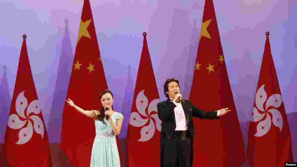 Singers perform in front of Hong Kong and China flags during a reception following a flag-raising ceremony celebrating the 65th anniversary of China National Day in Hong Kong, Oct. 1, 2014 . 