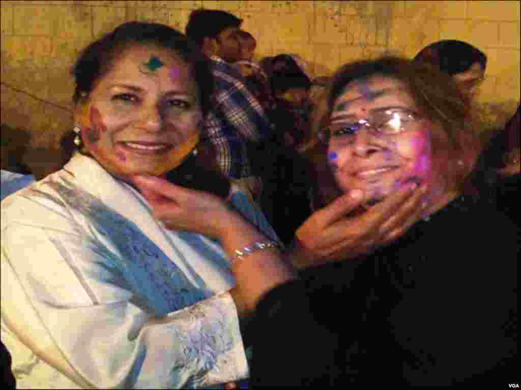 کراچی کے مندر میں ہولی کےدوران دو خواتین ایکدوسرے کو رنگ لگاتے ہوئے
