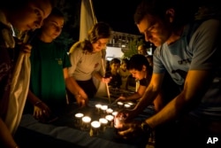 Israelis light candles in the Israeli settlement of Halamish, July 22, 2017. Israel's military has sent more troops to the West Bank and placed forces on high alert a day after a Palestinian stabbed to death three members of an Israeli family.