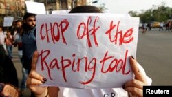 FILE - A woman holds a placard during a protest against the rape of an eight-year-old girl in Kathua near Jammu, and a teenager in Unnao, Uttar Pradesh state, in Kolkata, India, April 19, 2018. 