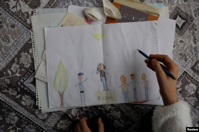 Putri Azam Jangravi menggambar sebuah gambar ibunya dalam unjuk rasa, 7 Februari 2019.(Foto: Reuters)