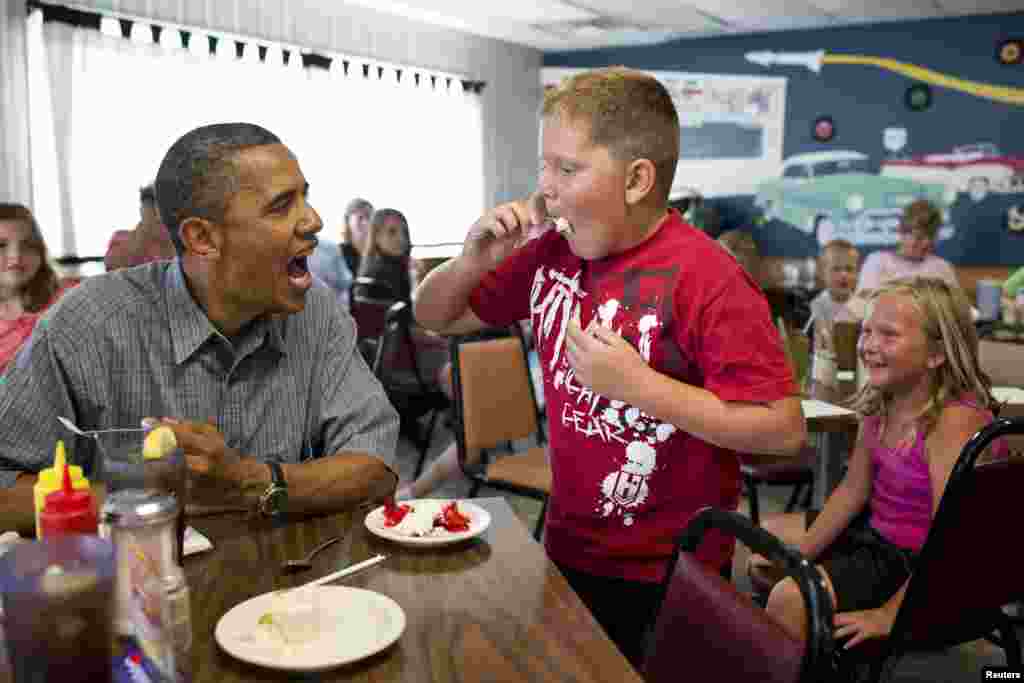 El presidente Barack Obama comparte su pastel de fresas con un muchacho en Oak Harbor, Ohio.
