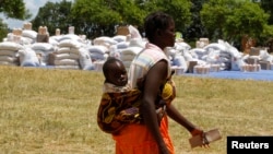 Une femme avec un enfant au dos est parmi les personnes touchées par la sécheresse en Angola, au Lesotho, an Malawi, et au Zimbabwe, 7 mars 2013. 
