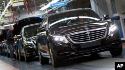 FILE - A Mercedes-Benz AG employee checks a S-Class model at the plant in Sindelfingen, Germany, Jan. 28, 2015. The pact between the world's largest maker of premium cars and the world's largest automotive supplier forms a powerful counterweight to ride-hailing firms Uber and Didi, which are also working on self-driving cars. 