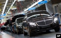 FILE - A Mercedes-Benz AG employee checks a S-Class model at the plant in Sindelfingen, Germany, Jan. 28, 2015.