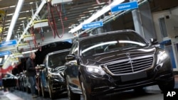 FILE - A Mercedes-Benz AG employee checks a S-Class model at the plant in Sindelfingen, Germany, Jan. 28, 2015. 