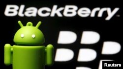 FILE - An Android mascot is seen in front of a BlackBerry logo in this photo illustration taken June 12, 2015.