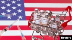 A small shopping basket filled with vials labeled "COVID-19 - Coronavirus Vaccine" and medical syringes are placed on a U.S. flag in this illustration taken November 29, 2020. Picture taken November 29, 2020. (REUTERS/Dado Ruvic/Ilustration)