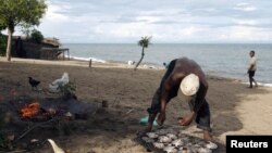 A fisherman prepares fish beside Lake Malawi, 120 km (75 miles) east of the capital Lilongwe, Malawi, April 3, 2009. 