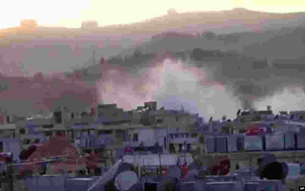 This image taken from video obtained from the Shaam News Network shows smoke rising from buildings after an artillery bombardment on the outskirts of Damascus, Sept. 5, 2013. 