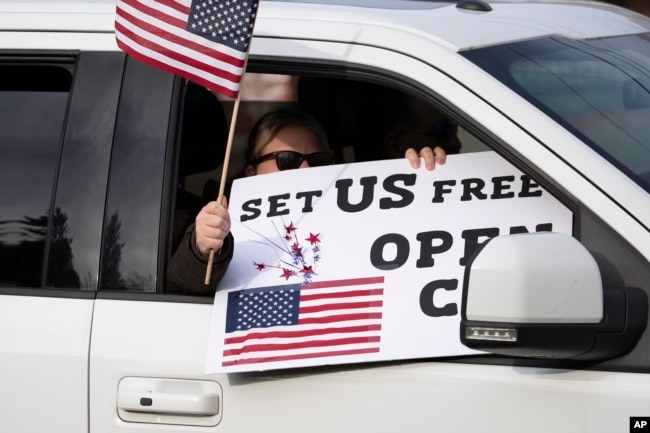 Estadounidenses participan en una manifestación para exigir la reapertura de la economía cerrada por el coronavirus el 20 de abril de 2020 en Hartford, Connecticut.