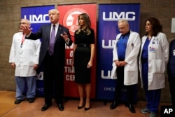 President Donald Trump talks as first lady Melania Trump and surgeon Dr. John Fildes, left, listens at the University Medical Center after Trump met with survivors of the mass shooting, Oct. 4, 2017, in Las Vegas.