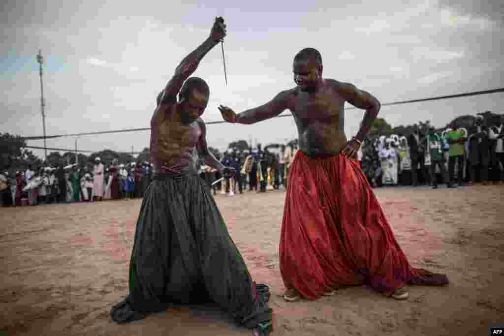 Performers from the Joles ethnic group in Gambia prepare to perform with sharp blades which they say will demonstrate the magic powers of a spiritual water, that will make them immune to the cuts, during a campaign rally by incumbent President Yahya Jamme, leader of the APRC (The Alliance for Patriotic Reorientation and Construction) in Bikama.