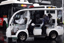 湖北武漢一所醫院外身穿防護服的工作人員駕駛一輛運送新冠病毒感染者的車輛。（2020年2月15日）