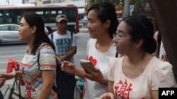 FILE - wife of detained human rights lawyer Xie Yang, with other wives of detained human rights lawyers including Fan Lili (L), the wife of Ge Ping, and Wang Yanfang (C), the wife of Tang Jingling, outside the Supreme People’s Procuratorate wearing the na