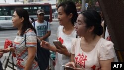 FILE - The wife of detained human rights lawyer Xie Yang gathers with other wives of detained human rights lawyers, including Fan Lili, left, the wife of Ge Ping, and Wang Yanfang, center, the wife of Tang Jingling, outside the Supreme People’s Procuratorate, July 4, 2016.