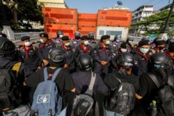 Pengunjuk rasa pro-demokrasi berhadapan dengan polisi anti huru hara dalam aksi unjuk rasa menuntut reformasi monarki dan pengunduran diri pemerintah di Bangkok, Thailand 10 Desember 2020.