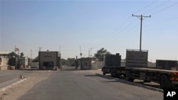 Des camions se garent devant la porte du côté palestinien du terminal de cargaison israélien de Kerem Shalom à Rafah, au sud de la bande de Gaza.