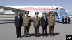 Delegasi Korea Utara yang dipimpin oleh Choe Ryong Hae, pemimpin Biro Politik Korea Utara (KPA) (tengah), berpose sejenak di bandara Pyongyang sebelum bertolak ke China untuk kunjungan dua hari (22/5). Delegasi ini telah mengakhiri kunjungannya ke China setelah melakukan serangkaian pertemuan dengan para pejabat setempat.