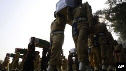 Pakistan soldiers carry the coffins of troops killed during an accidental NATO strike at a funeral in Peshawar, Pakistan, Nov. 27, 2011. 