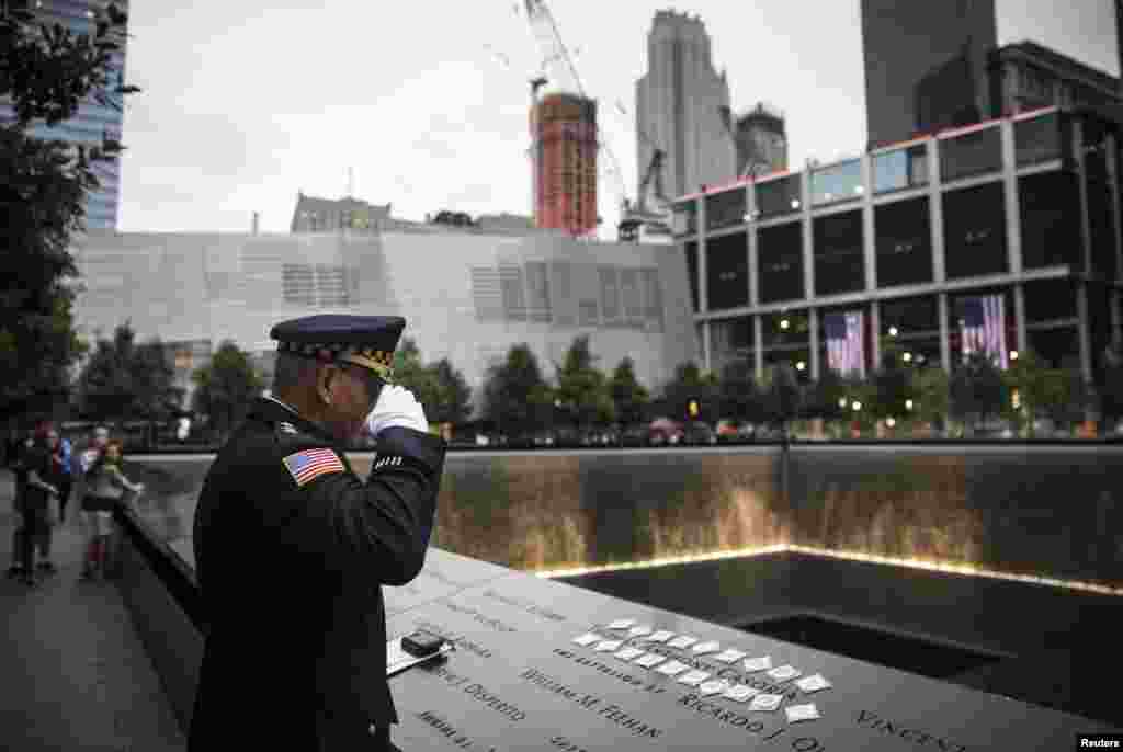 Sam Pulia, mayor of Westerchester, Illinois and a former police officer salutes the name of his cousin, New York firefighter Thomas Anthony Casoria, who was killed in the South Tower, prior to the memorial observances held at the site of the World Trade Center in New York, Sept. 11, 2014.