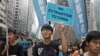 FILE - Protesters with placards and flags against an extradition law march toward the government headquarters in Hong Kong, March 31, 2019.