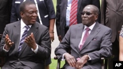 Emmerson Mnangagwa, left, Vice President of Zimbabwe chats with Zimbabwean President Robert Mugabe after the swearing in ceremony at State House in Harare, Dec, 12, 2014. 