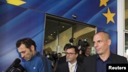 Greek Finance Minister Yanis Varoufakis (R) leaves the European Commission headquarters in Brussels, May 5, 2015. 