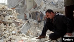 Một người đàn ông ngồi khóc tại một địa điểm bị trúng phi đạn Scud tại Ard al-Hamra thuộc thành phố Aleppo, 23/2/2013