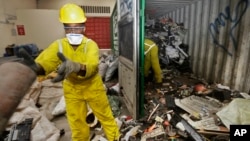 FILE - Workers unload and sort through a container full of electronic waste that was collected from a Nairobi slum and brought in for recycling, at the East African Compliant Recycling facility in Machakos, near Nairobi, in Kenya, Aug. 18. 2014.